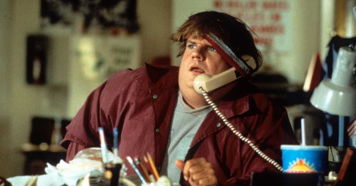 Chris Farley holding a phone receiver underneath his headband to keep it propped up to his ear in a scene from the film 'Black Sheep', 1996. (Cover Image Source: Photo by Paramount Pictures/ Getty Images)