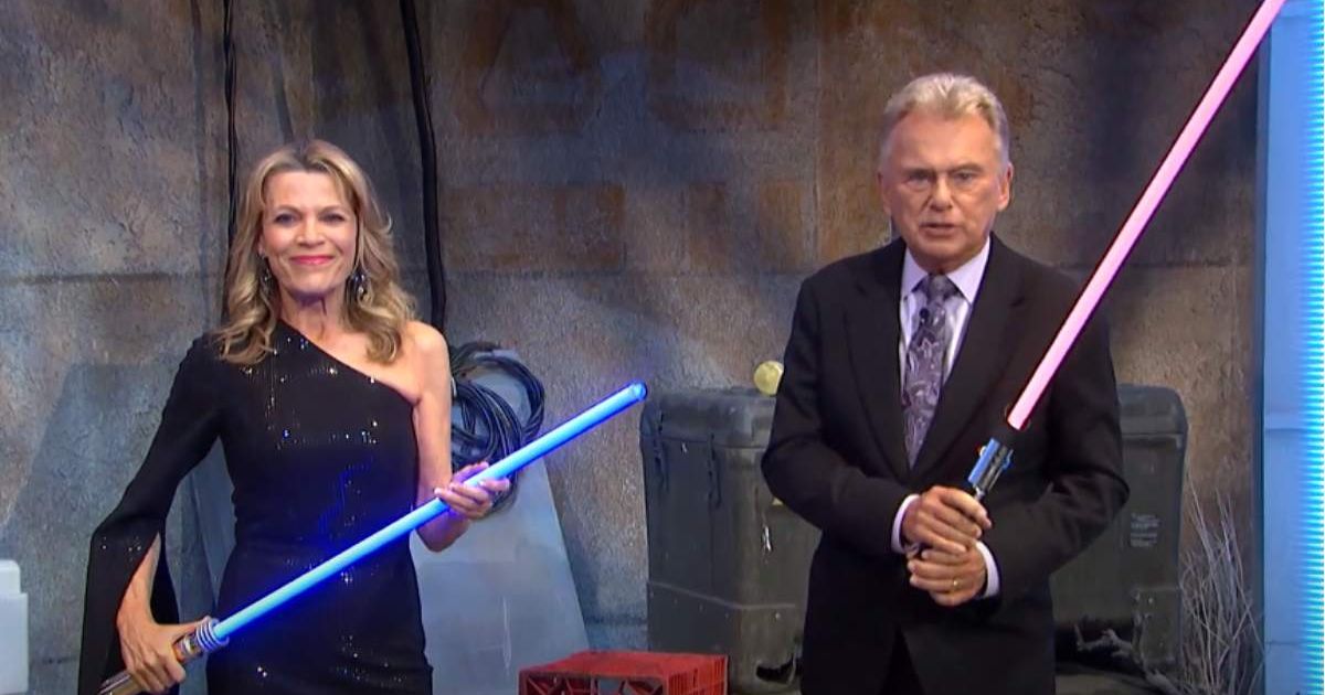 Screenshot of 'Wheel of Fortune' hosts Vanna White and Pat Sajak with their lightsabers during the ‘Star Wars’ week. (Cover Image Source: YouTube | Wheel of Fortune)
