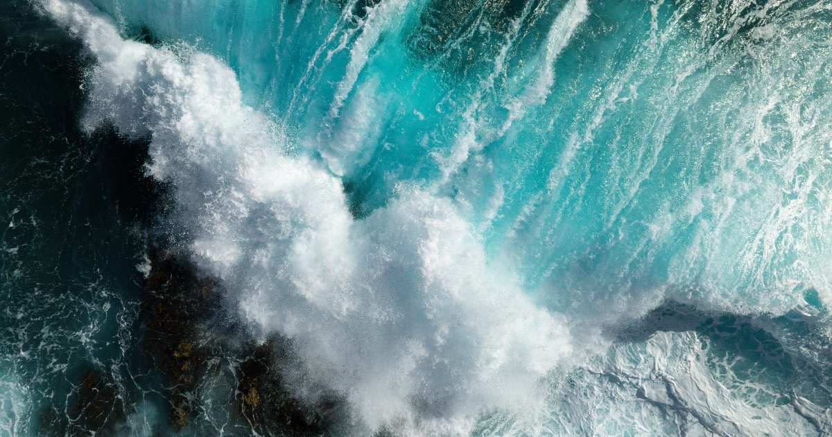 Top-down aerial view of waves breaking on a rocky shoal during a strong wind day. (Representative Cover Image Source: Getty Images | Photo by Air Creative)