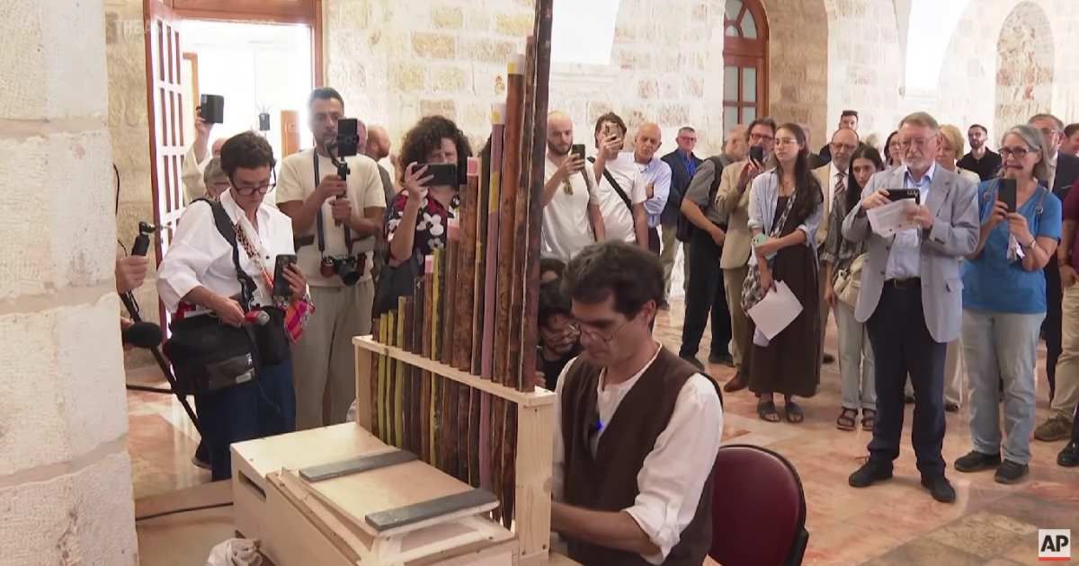 A man plays the oldest pipe organ in the Christian world in Jerusalem, while the public is listening. (Cover Image Source: Associated Press (AP))