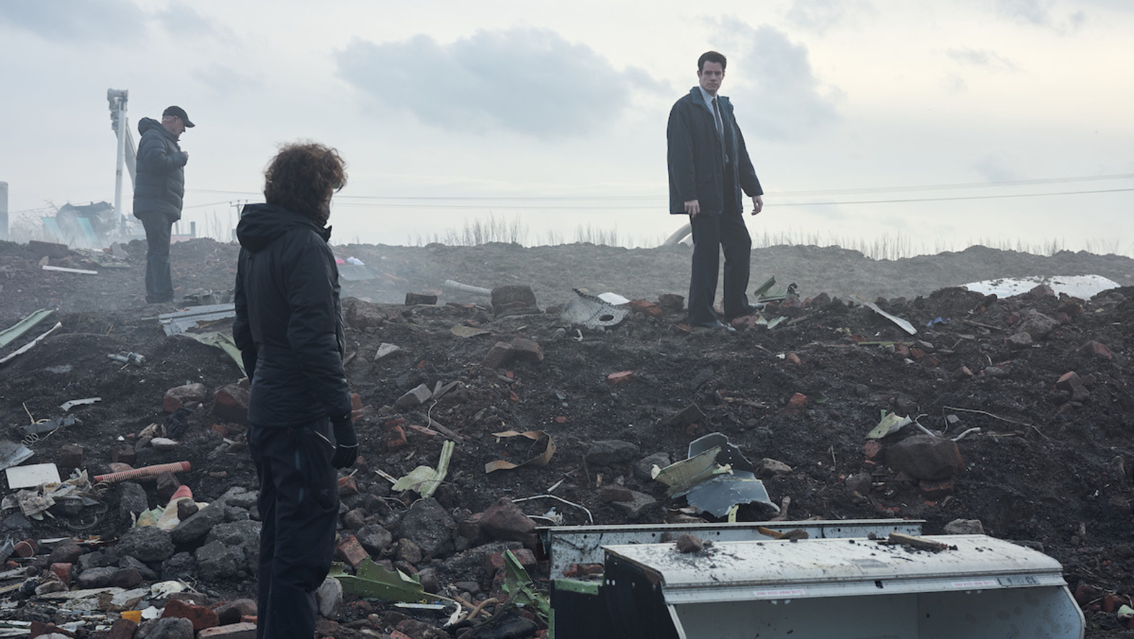 Connor Swindells as Ed McCusker surveys the wreckage connected to the Pan Am Flight 103 bombing in ‘The Bombing of Pan Am 103’ (Image Source: Netflix | Tudum)
