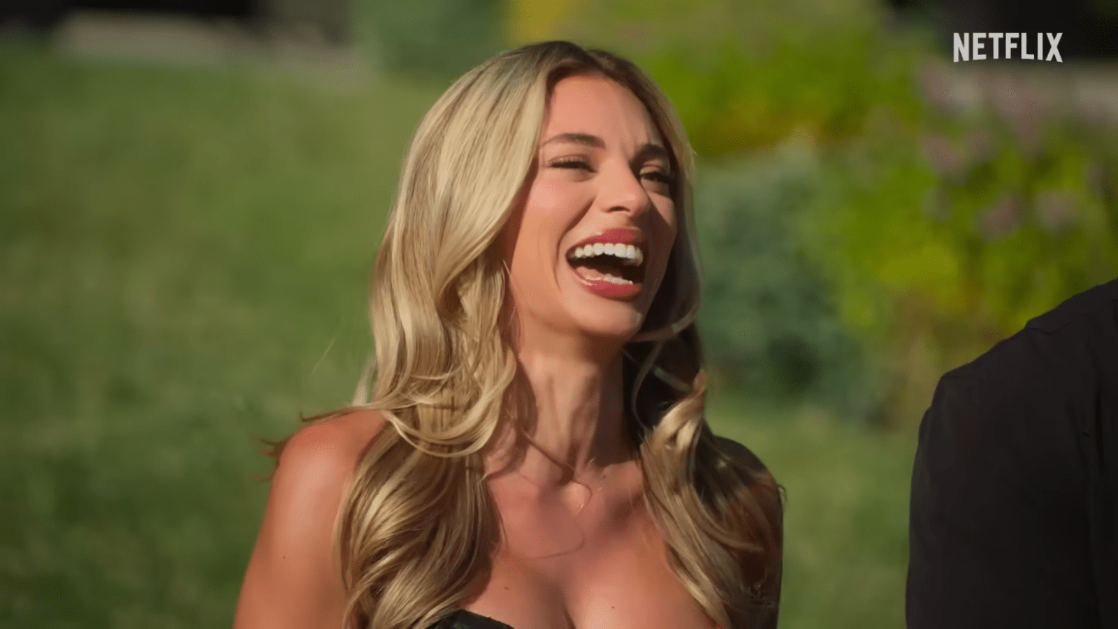 Georgia Hassarati laughs making a cheeky joke from the ‘Let’s Marry Harry’ trailer (Image Source: Netflix)
