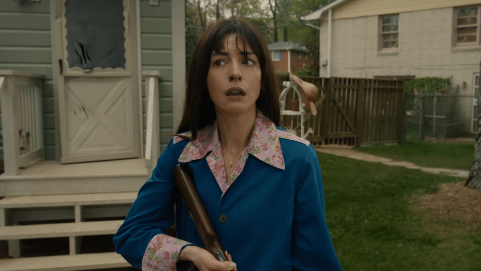 Anne Hathaway as Denise Platt holds a shotgun in ‘The End of Oak Street’ (Image Source: YouTube | Warner Bros. Pictures)