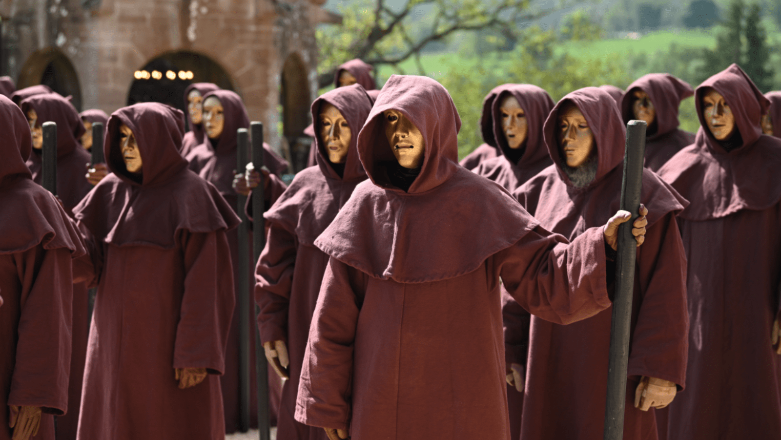 Masked figures gather outside the castle in ‘The Traitors: New Blood’ (Image Source: NBC | Photo by Euan Cherry)