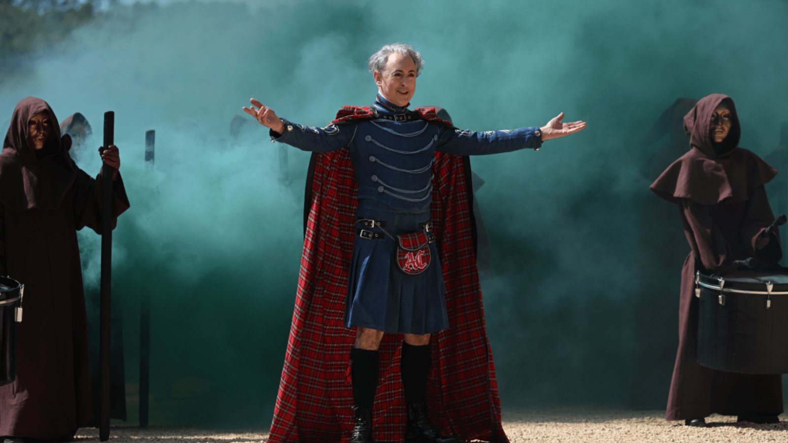 Alan Cumming stands among masked figures in ‘The Traitors: New Blood’ (Image Source: NBC | Photo by Euan Cherry)