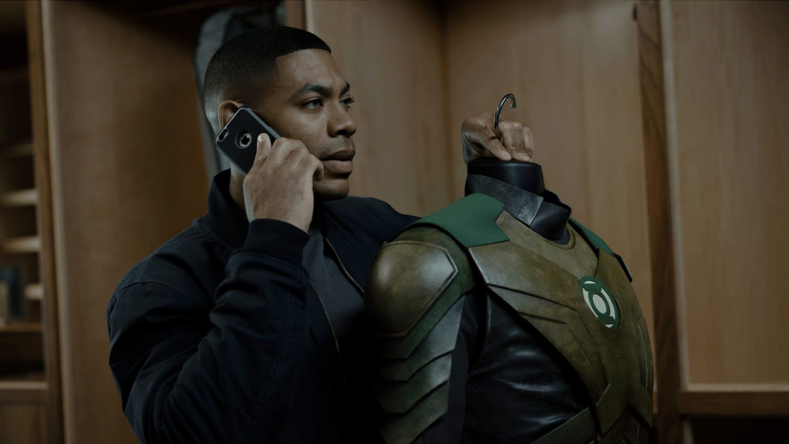 Aaron Pierre as John Stewart holds a Green Lantern suit while speaking on the phone in ‘Lanterns’ (Image Source: HBO | Warner Bros. Discovery)