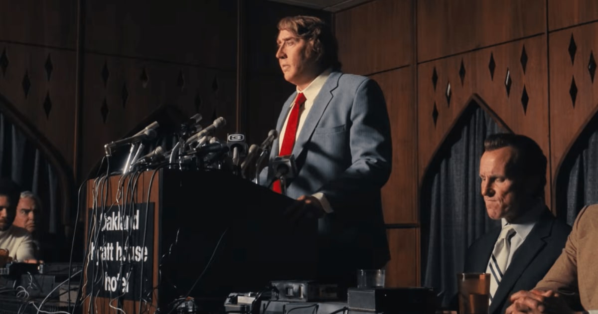 Nicolas Cage as John Madden speaks at a press conference in a still from the trailer of ‘Madden’ (Cover Image Source: YouTube | Prime Video)
