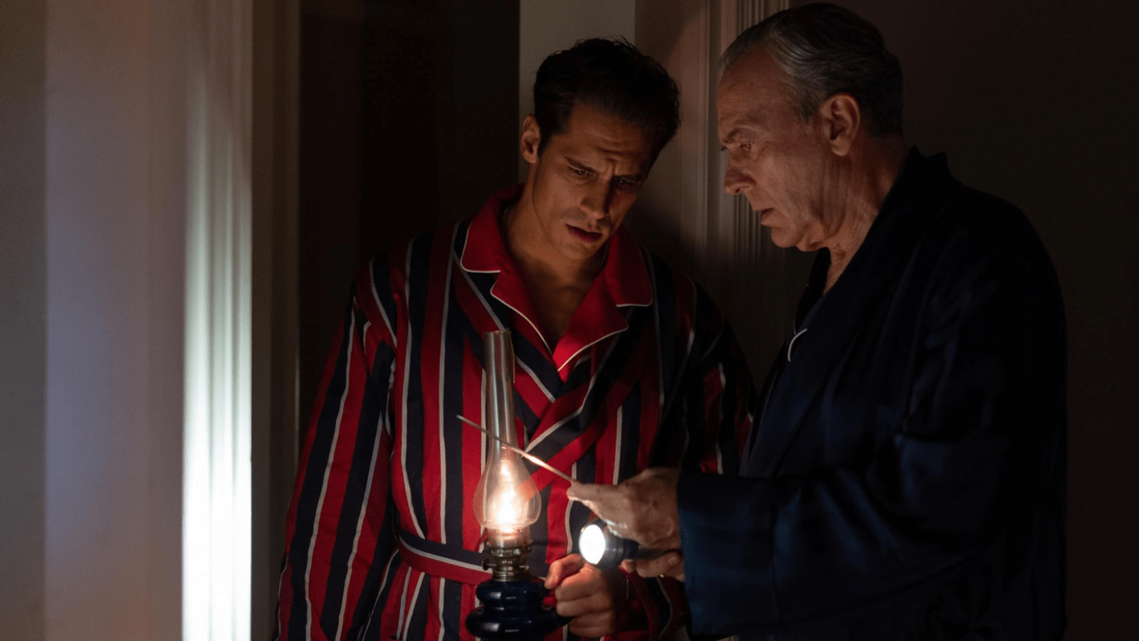 Basil and Foxa examine an object by lamplight in a scene from 'The Final Problem' (Image Source: Netflix)